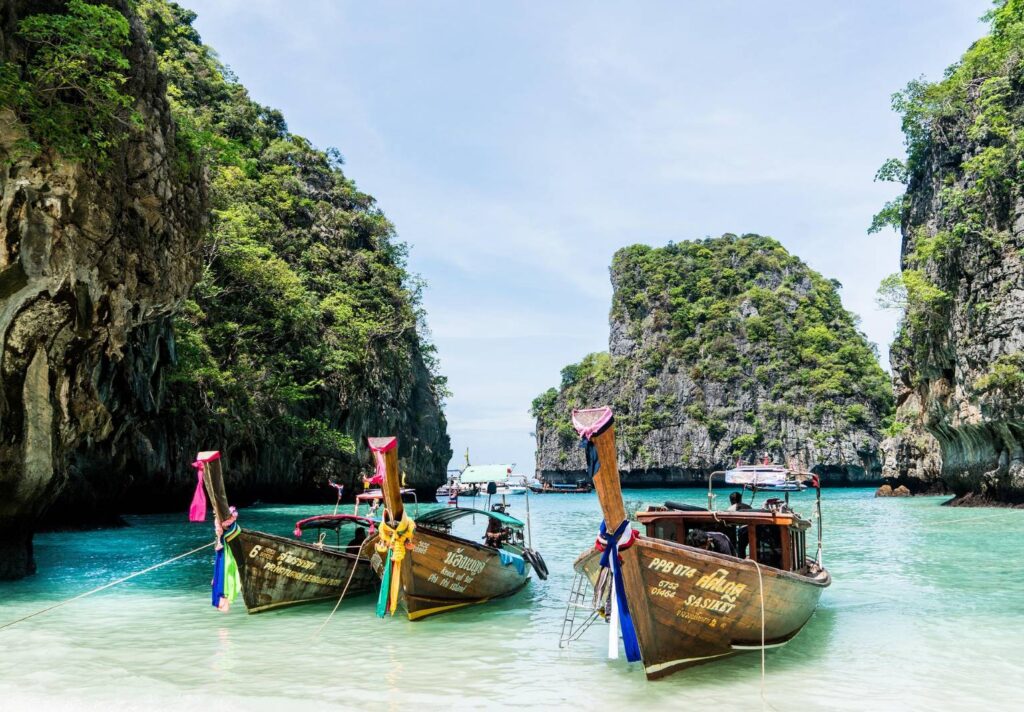 ทัวร์เกาะพีพีและทะเลอันดามัน เรือหางยาวท่ามกลางน้ำทะเลและหน้าผาหินปูน