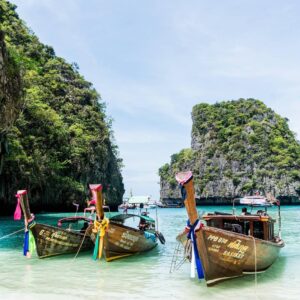 ทัวร์เกาะพีพีและทะเลอันดามัน เรือหางยาวท่ามกลางน้ำทะเลและหน้าผาหินปูน