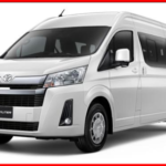 รถตู้ Toyota Commuter สีขาว มุมเฉียงด้านหน้าและด้านข้าง สำหรับบริการรถตู้พร้อมคนขับ