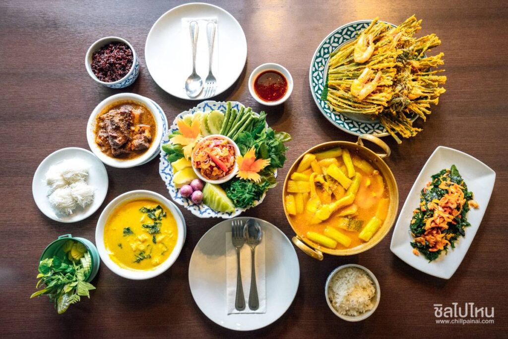 ภาพสำรับอาหารไทยภาคใต้หลากหลายเมนู จัดเสิร์ฟบนโต๊ะอาหาร ประกอบด้วยแกงพื้นบ้าน น้ำพริก ผักสด อาหารทอด และเครื่องเคียง สะท้อนเอกลักษณ์วัฒนธรรมอาหารภาคใต้ เหมาะสำหรับประกอบเนื้อหาแนะนำทัวร์สายกินภูเก็ต การค้นหาร้านอาหารพื้นเมือง และประสบการณ์ท่องเที่ยวเชิงอาหารกับ Safe Phuket Travel